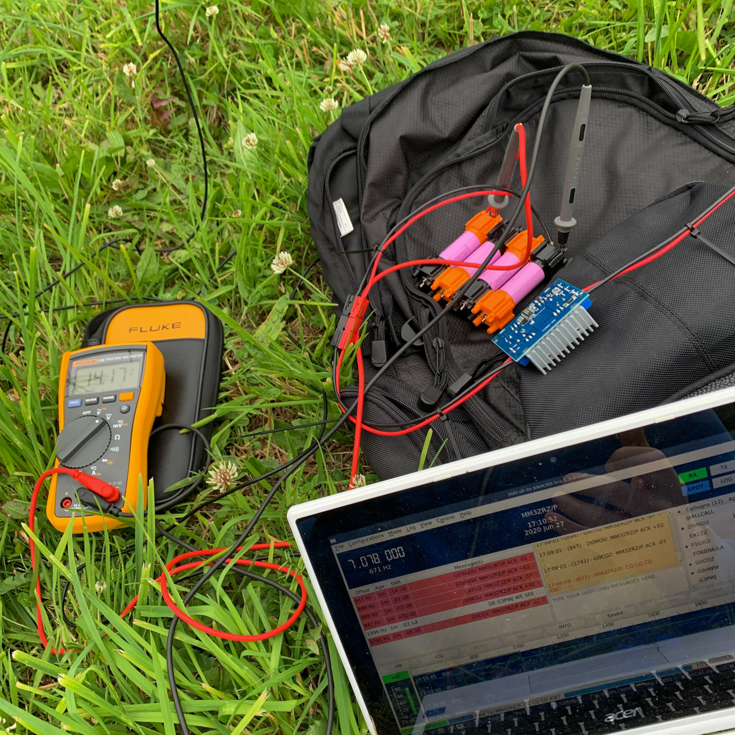 A photograph of a battery pack connected to a multimeter monitoring voltage